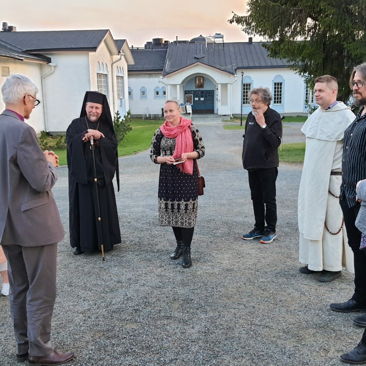 Hallituksen jäseniä seisoo keskustelemassa Valamon luostarin pihalla kesällä 2023.